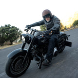Person riding a motorcycle on a road with a scenic background
