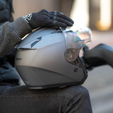 Person holding a motorcycle helmet with a blurred background