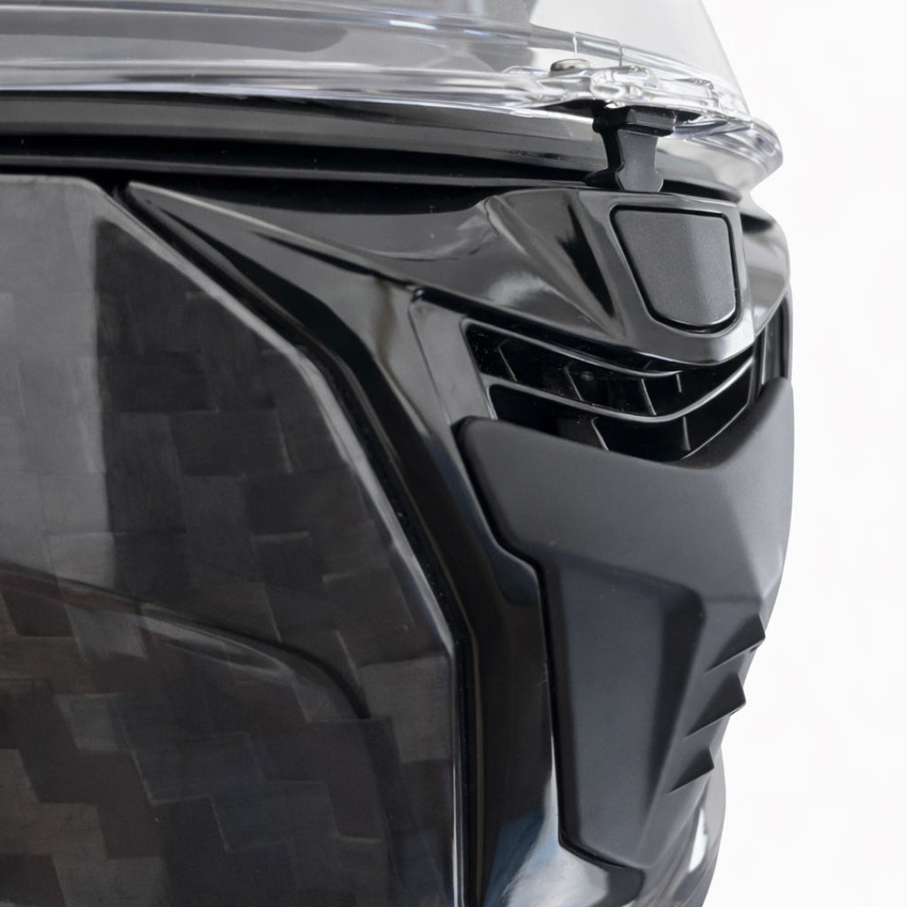 Close-up of a black motorcycle helmet with a clear visor on a white background